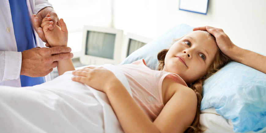 Niña en cama de hospital sonriendo