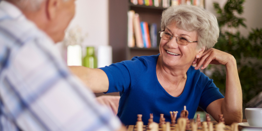 Mujer riendo mientras juega al ajedrez